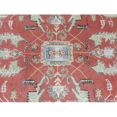 94 - A pair of terracotta ground Kazak style rug with all over geometric patterned ground with multicolou... 