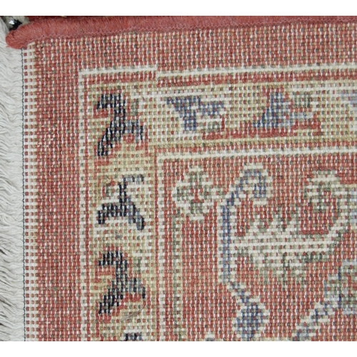 94 - A pair of terracotta ground Kazak style rug with all over geometric patterned ground with multicolou... 