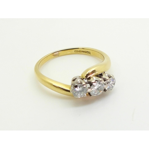 719 - An 18ct gold three stone on a twist, set with estimated approx 0.40cts of brilliant cut diamonds, fi... 