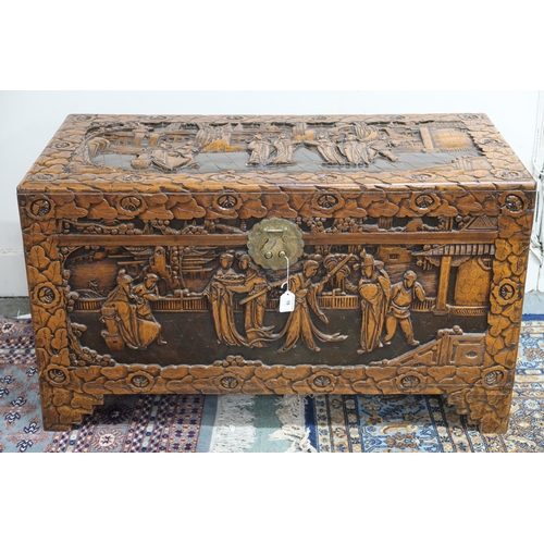 18 - A 20th century Chinese camphorwood blanket chest, carved with village scenes on shaped feet, 59cm hi... 