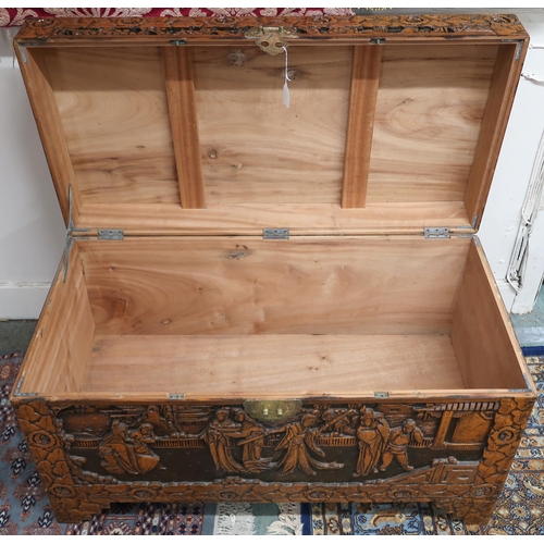 18 - A 20th century Chinese camphorwood blanket chest, carved with village scenes on shaped feet, 59cm hi... 