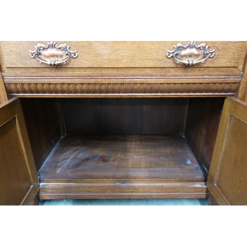 35 - A late Victorian oak sideboard with two central drawers over pair of carved cabinet doors flanked by... 