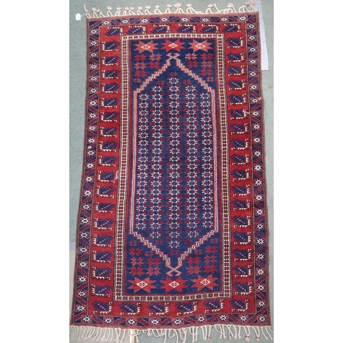 64 - A blue ground Balouch rug with geometric patterned central ground and red and blue geometric border,... 