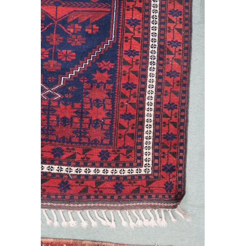 65 - A dark blue ground Balouch rug with red geometric central pattern and red geometric border, 198cm lo... 