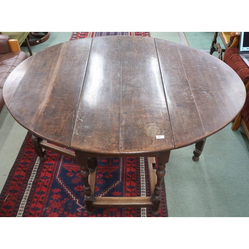 67 - An 18th century oak drop leaf table with oval drop end top over drawers to either end on turned supp... 