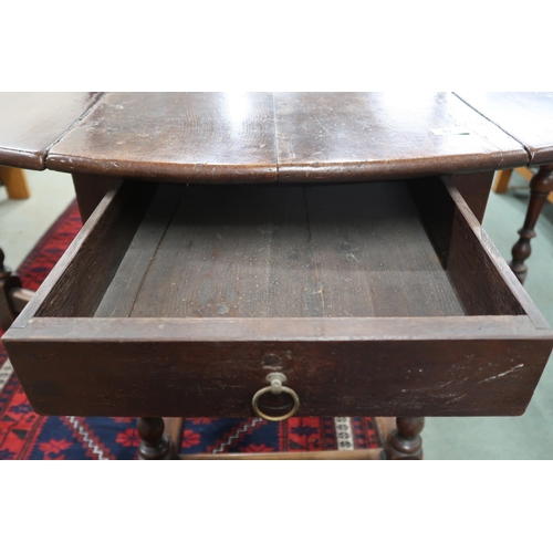 67 - An 18th century oak drop leaf table with oval drop end top over drawers to either end on turned supp... 