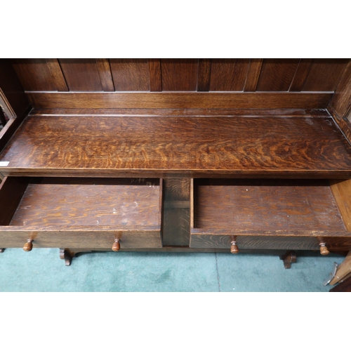 24 - A 20th century oak Wylie & Lochhead kitchen dresser with two tier plate rack over pair of drawer... 