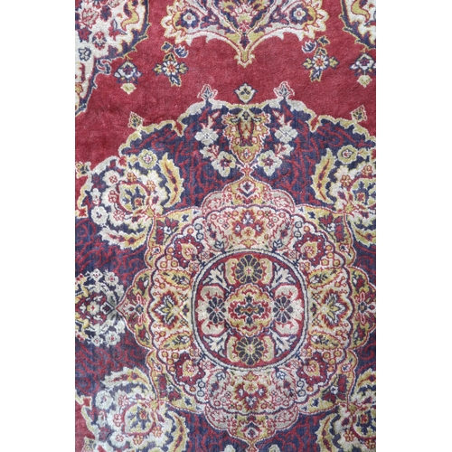 30 - A red ground Tabriz style wall tapestry with multicoloured central medallion, beige spandrels and mu... 