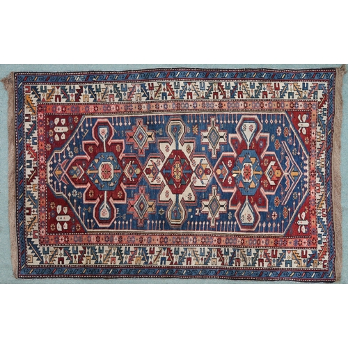 2130 - A BLUE GROUND CAUCASIAN KAZAK RUG with three red and beige medallions on geometric pattern ground wi... 