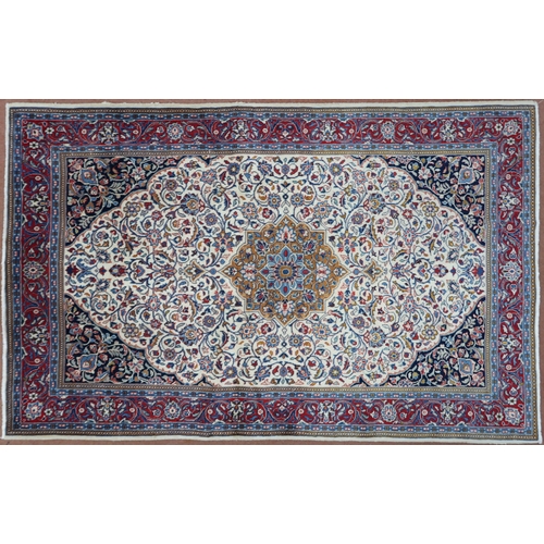 2137 - A CREAM GROUND KASHAN RUG with yellow and blue central medallion and dark blue spandrels on a floral... 