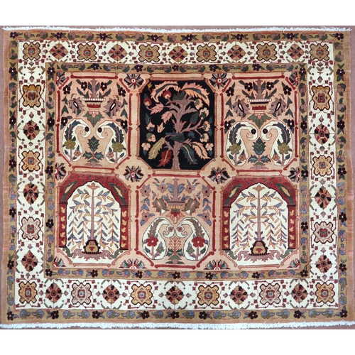 2138 - A PEACH GROUND HERIZ RUG decorated with six panelled ground with foliate and urn designs and flower ... 