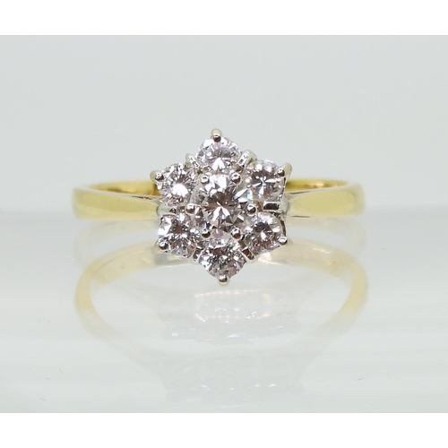 707 - An 18ct gold diamond flower ring, set with estimated approx 0.75cts of brilliant cut diamonds, finge... 