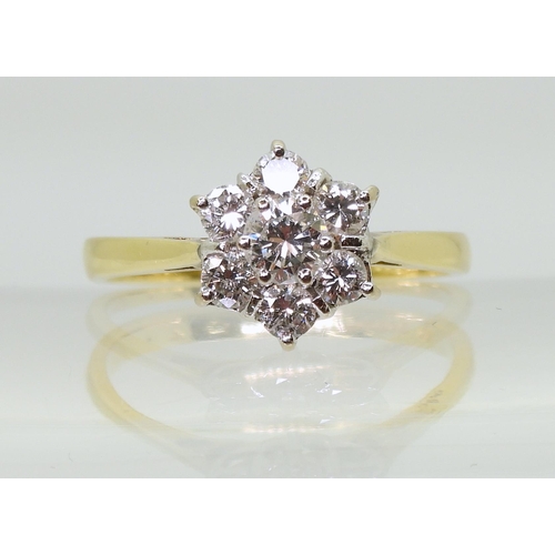 707 - An 18ct gold diamond flower ring, set with estimated approx 0.75cts of brilliant cut diamonds, finge... 