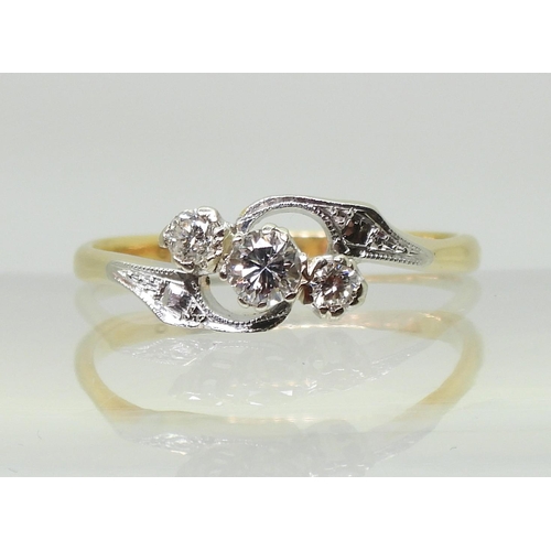 713 - An 18ct and platinum vintage three stone diamond ring, with pretty on a twist design, set with estim... 