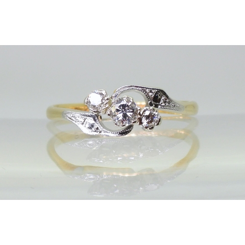 713 - An 18ct and platinum vintage three stone diamond ring, with pretty on a twist design, set with estim... 