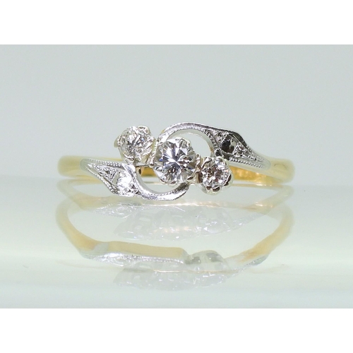 713 - An 18ct and platinum vintage three stone diamond ring, with pretty on a twist design, set with estim... 