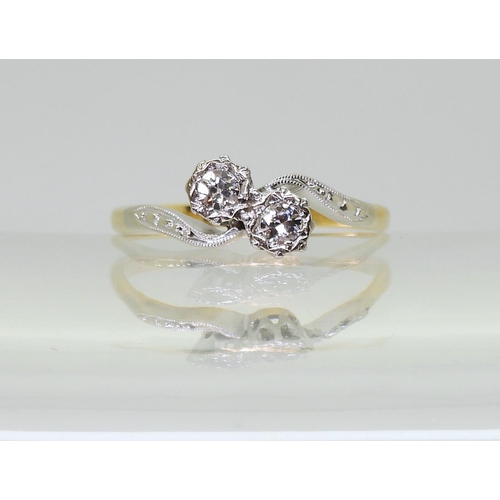 714 - An 18ct and platinum twin stone on a twist ring, set with two brilliant cut diamonds of estimated ap... 