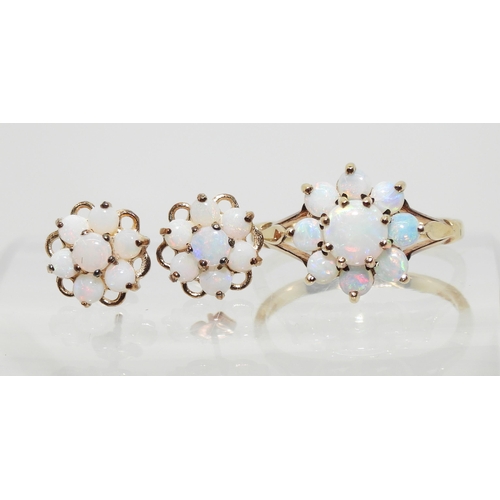 717 - A 9ct gold opal flower ring with matching earrings. Finger size J, weight with the earrings 2.8gms