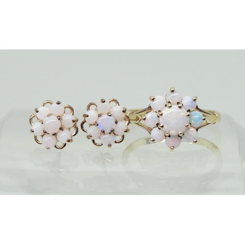 717 - A 9ct gold opal flower ring with matching earrings. Finger size J, weight with the earrings 2.8gms