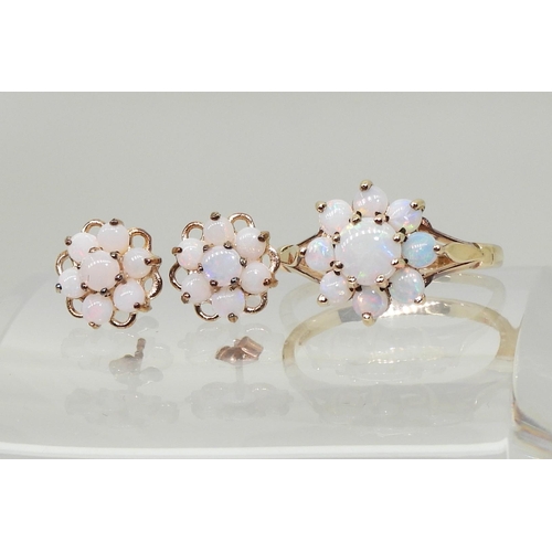 717 - A 9ct gold opal flower ring with matching earrings. Finger size J, weight with the earrings 2.8gms