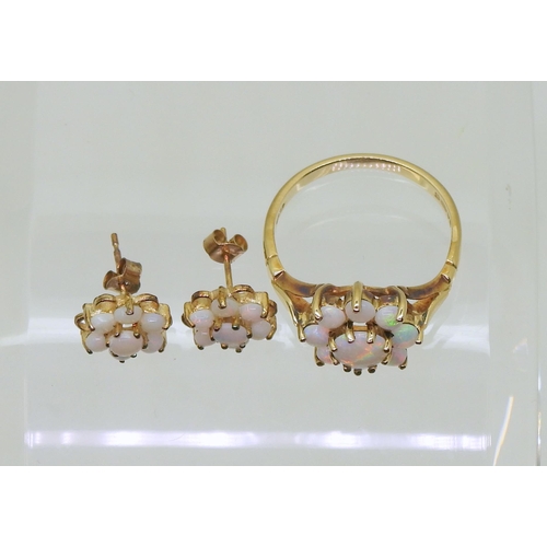 717 - A 9ct gold opal flower ring with matching earrings. Finger size J, weight with the earrings 2.8gms