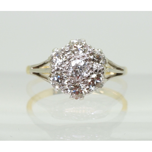 731 - An 18ct gold and platinum diamond flower ring with fleur de lis shoulders, set with estimated approx... 