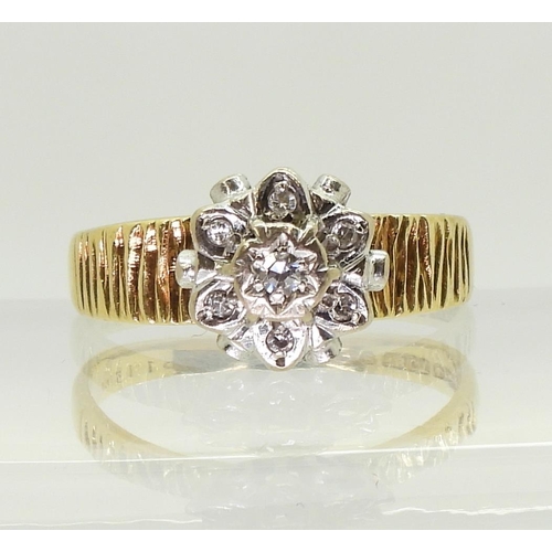 750 - An 18ct gold diamond retro flower ring set with diamond accents, and bark textured shoulders, finger... 