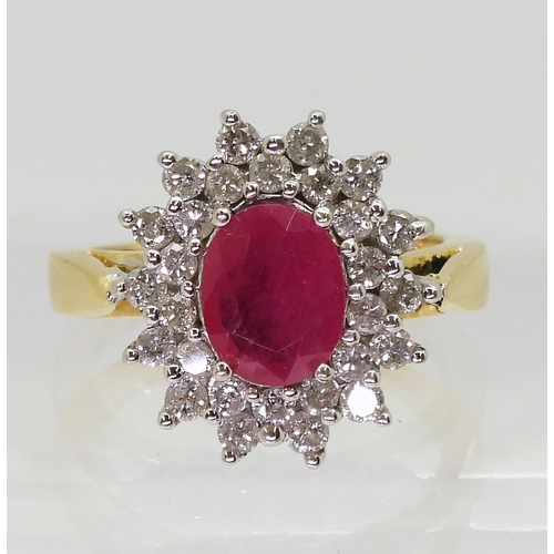 752 - An 18ct gold ruby and diamond cluster ring, set with a  8.7mm x 6.8mm, oval cut ruby, and set w... 