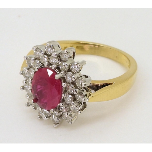 752 - An 18ct gold ruby and diamond cluster ring, set with a  8.7mm x 6.8mm, oval cut ruby, and set w... 