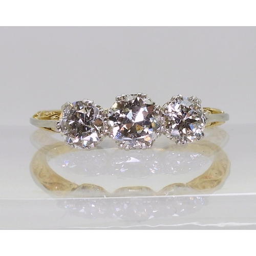 753 - A 1930s vintage three stone diamond ring, with a pretty platinum and 18ct yellow gold scroll mount, ... 