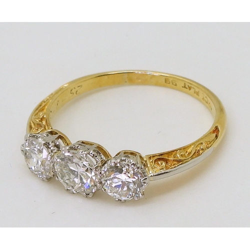 753 - A 1930s vintage three stone diamond ring, with a pretty platinum and 18ct yellow gold scroll mount, ... 