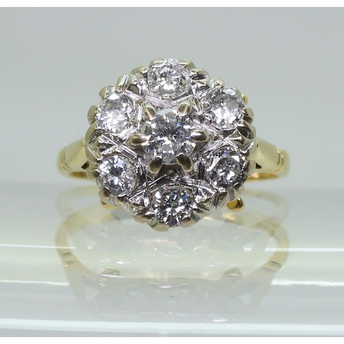 754B - An 18ct gold diamond flower ring with fleur de Lis shoulders, set with estimated approx 0.85cts of b... 