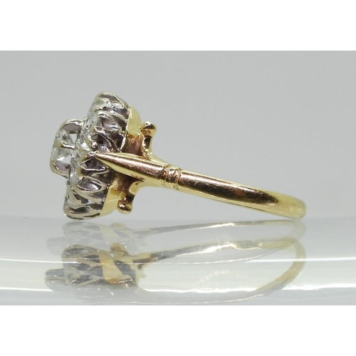 754B - An 18ct gold diamond flower ring with fleur de Lis shoulders, set with estimated approx 0.85cts of b... 