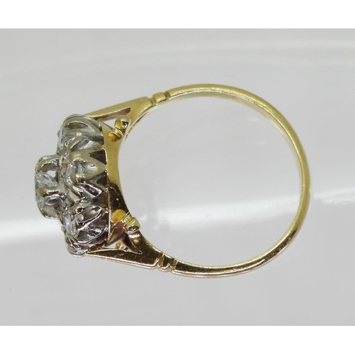 754B - An 18ct gold diamond flower ring with fleur de Lis shoulders, set with estimated approx 0.85cts of b... 