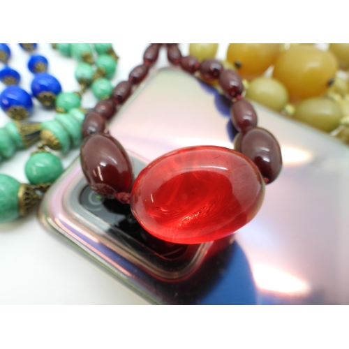 765 - A string of cherry amber coloured beads, with two loose faceted examples weight together 37.7gms, tw... 