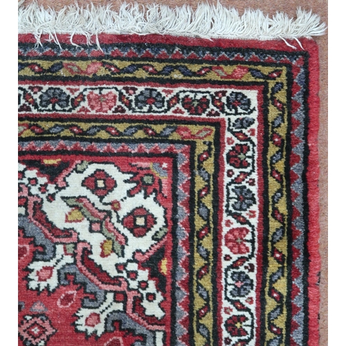 18 - A red ground hamadan rug with cream central medallion, matching spandrels and multiple borders, 162c... 