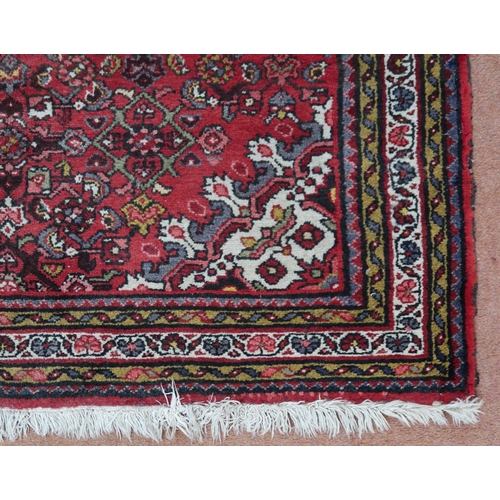 18 - A red ground hamadan rug with cream central medallion, matching spandrels and multiple borders, 162c... 