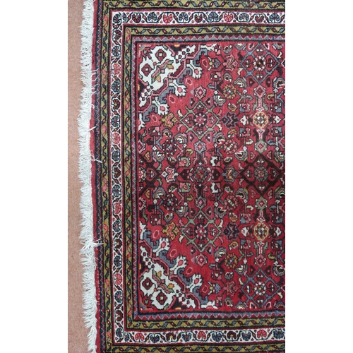 18 - A red ground hamadan rug with cream central medallion, matching spandrels and multiple borders, 162c... 