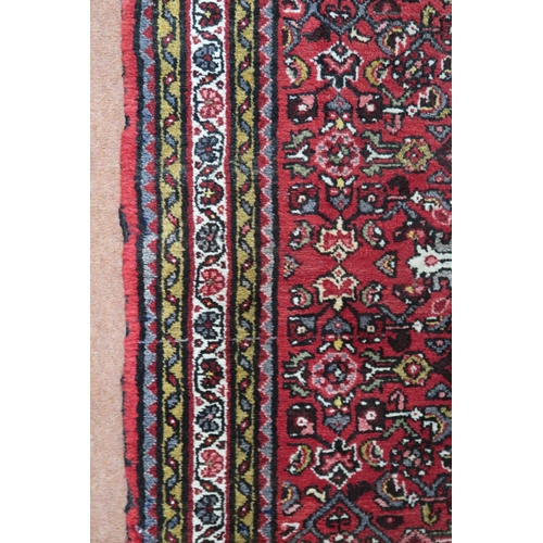 18 - A red ground hamadan rug with cream central medallion, matching spandrels and multiple borders, 162c... 