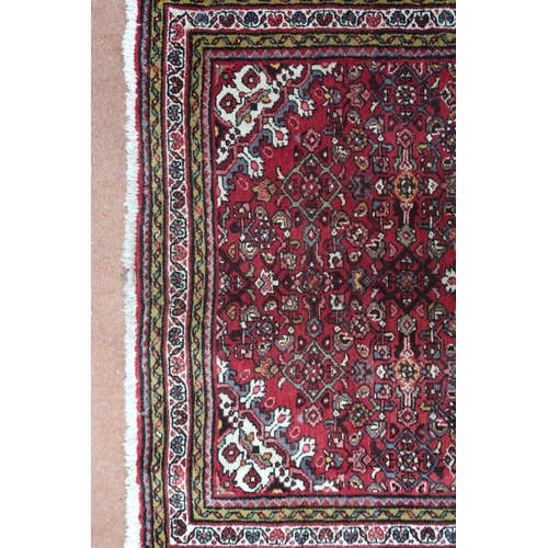 18 - A red ground hamadan rug with cream central medallion, matching spandrels and multiple borders, 162c... 