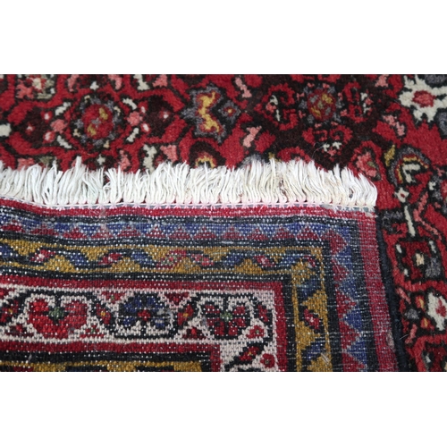 18 - A red ground hamadan rug with cream central medallion, matching spandrels and multiple borders, 162c... 