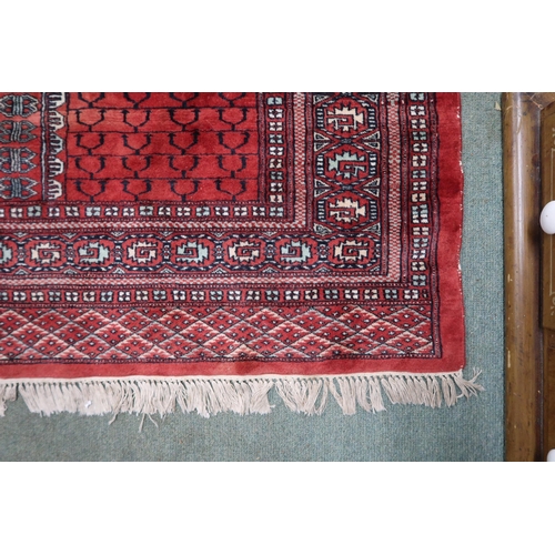 28 - A red ground Turkaman rug with four panelled ground with multicoloured geometric border, 190cm long ... 