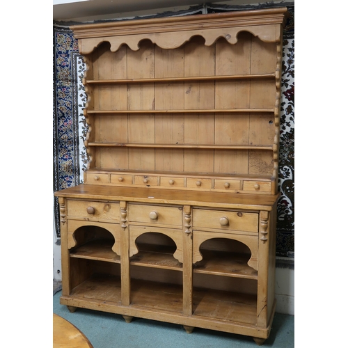 38 - A 20th century pine Welsh style kitchen dresser with open plate rack on base with three drawers over... 