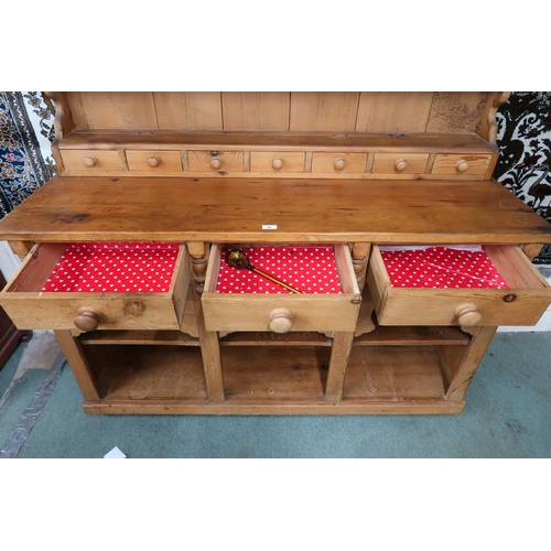 38 - A 20th century pine Welsh style kitchen dresser with open plate rack on base with three drawers over... 