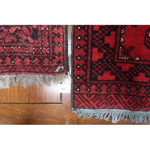 41 - A lot comprising red ground Bokhara rug, 92cm long x 53cm wide and another smaller example, 61cm lon... 