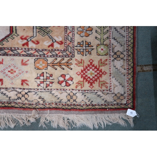 50 - A beige ground Turkish rug with red central column within geometric patterned ground with multicolou... 