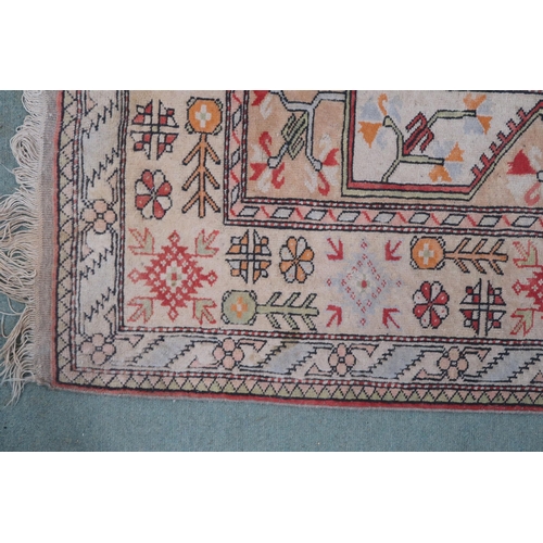 50 - A beige ground Turkish rug with red central column within geometric patterned ground with multicolou... 