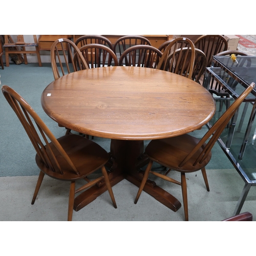 79 - A 20th century Ercol elm circular topped extending dining table and four mid 20th century Ercol elm ... 