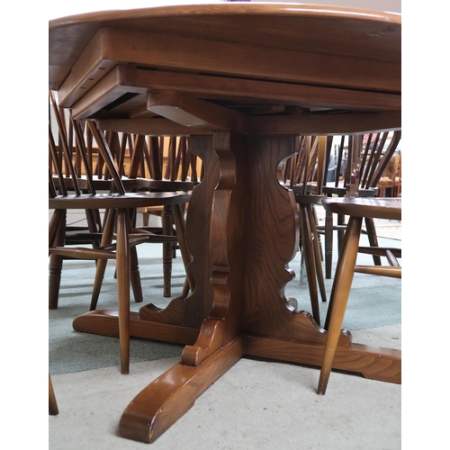 79 - A 20th century Ercol elm circular topped extending dining table and four mid 20th century Ercol elm ... 