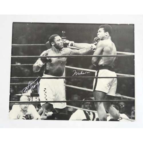 386 - A large black and white photograph of Muhammad Ali and Joe Frazier signed by both boxers in silver f... 